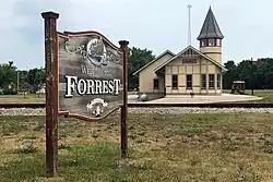 The sign for the town of Forrest, Illinois, with the railway museum in the background.