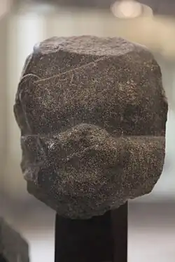 Fragment of the statue of a devotee, with inscription in the name of Naram-Sin: "To the god Erra, for the life of Naram-Sin, the powerful, his companion, the king of the four regions, Shu'astakkal, the scribe, the majordomo, has dedicated his statue".[121]