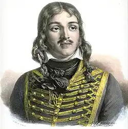 Color-tint print of a man with a moustache and hair reaching to his shoulders. He wears a dark hussar uniform of the 1790s.
