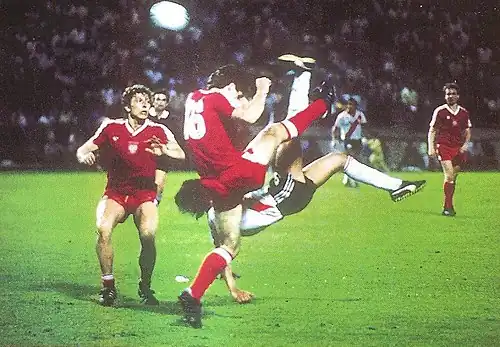 Photograph of a man striking a ball in mid-air
