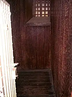 Cell with walls and floor covered in jarrah, held with an abundance of nails
