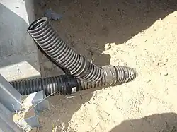A wye joining a perforated and a solid corrugated pipe to a buried solid outlet