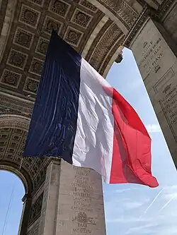 French flag suspended from the vault of the great archway