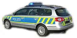 A police vehicle from Saxony-Anhalt. The vehicle is silver, with a blue panel with the word POLIZEI in white writing. It also carries some reflective yellow stripes.