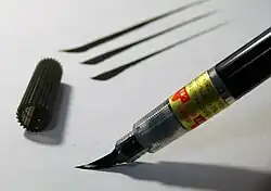 Picture of a brush pen being used to apply ink to paper