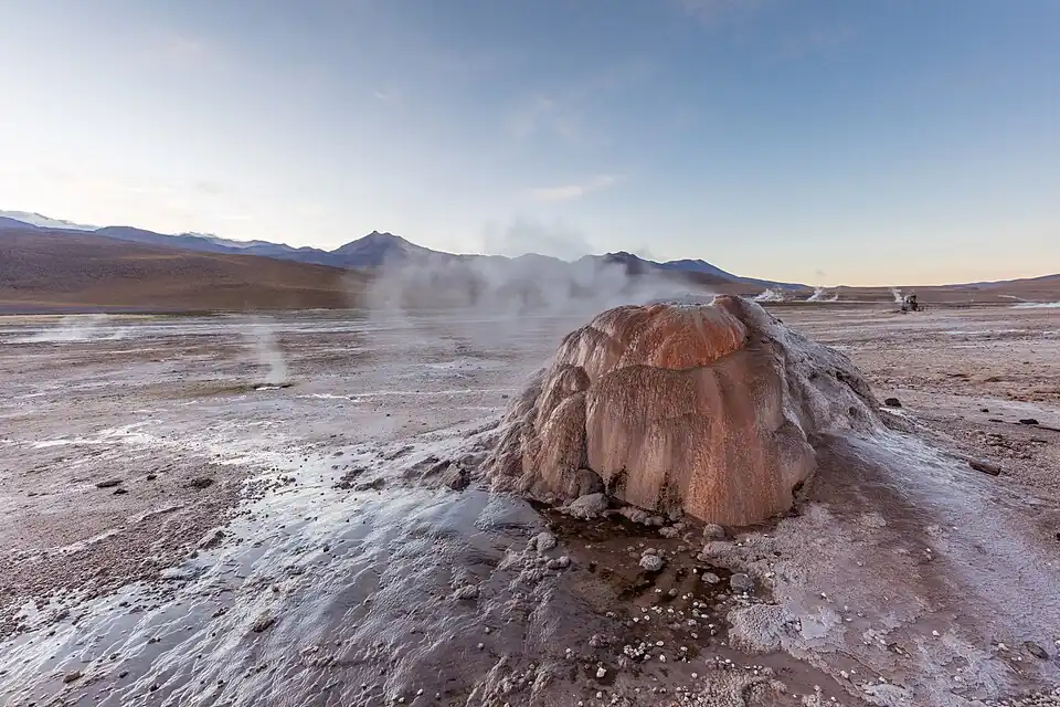 The vent is a small steaming cone with a polished appearance in an unvegetated landscape