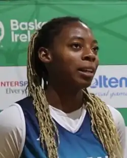 Headshot of Malou-Mamel in a blue jersey on a mostly green background