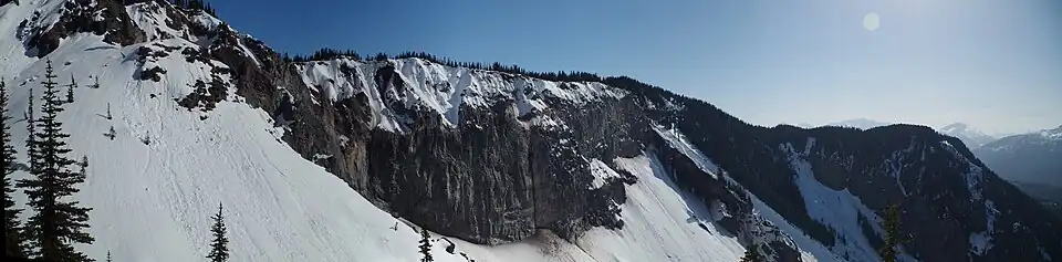 A rocky cliff partially covered with snow