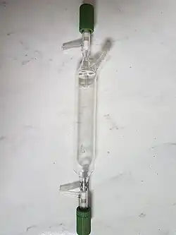 A long cylindrical tube with valves and angled inlets at either end