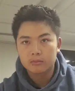 Headshot of a young man in a hoodie giving a blank stare