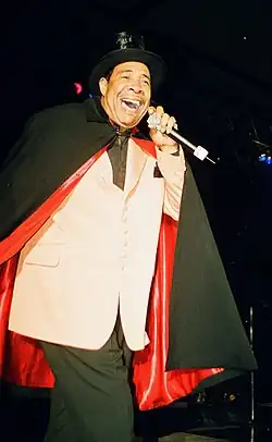 Chandler, smiling and singing onstage