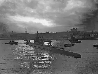 A black and white photo of a U-190 submarine at water level in a bay in 1945