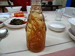 Ginseng roots in a bottle of liquid