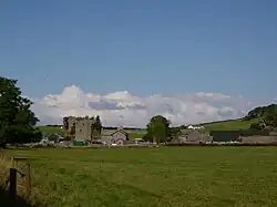 A mixture of old and modern buildings in a field.