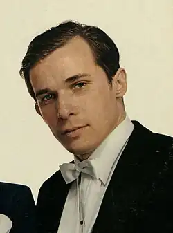 A profile of a man of about 50 playing a grand piano