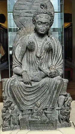 Statue of seated Hārītī with children from Yusufzai country around Peshawar, Pakistan in the British Museum, 2nd–3rd centuries CE[8]