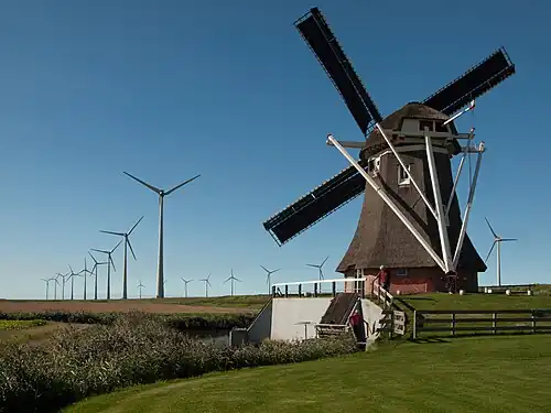 Image 2 Windmills Photograph: Uberprutser A windmill is a mill that converts the energy of wind into rotational energy by means of vanes called sails or blades. Traditional windmills were often used to mill grain, pump water, or both. Most modern windmills take the form of wind turbines used to generate electricity, or windpumps used to pump water, either for land drainage or to extract groundwater. Here, the smock mill Goliath is viewed in front of the wind farm Growind in Eemshaven in the Netherlands. More selected pictures