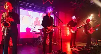 Gong at Club 85, Hitchin in 2025 From left to right: Ian East, Kavus Torabi, Cheb Nettles (obscured), Dave Sturt and Fabio Golfetti