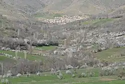 A village nestled between green hills