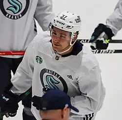 Ice hockey player in a Seattle Kraken jersey in front of other players