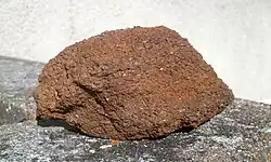 Color photograph and close-up of a medium-grained, reddish-brown stone.