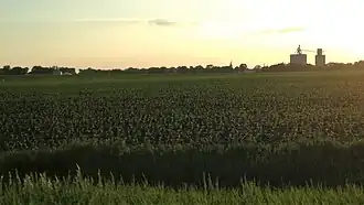 A grain elevator in the small town of Somers rises from a field at sunset