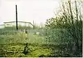 The station site, walking down from the crossing and past the signal box, towards the modern warehouse in 2003. The canal bridge is fenced off and collapsing.