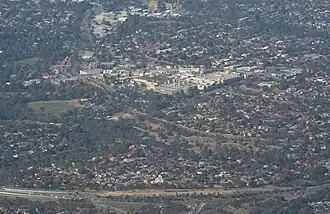 Aerial view from the north, Greensborough Bypass just in foreground, Greensborough Plaza in centre of image, and Greensborough railway station to left.