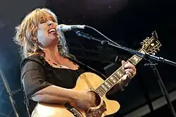 Singer Gretchen Peters performing while playing a guitar.
