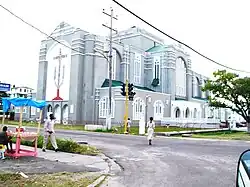 Photograph of the outside of a big grey and white church building