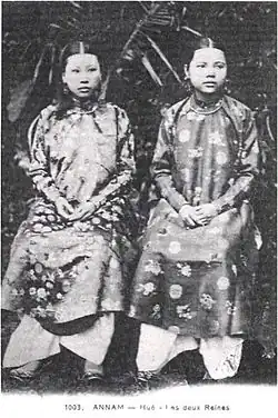 Photograph of two seated women wearing patterned outfits