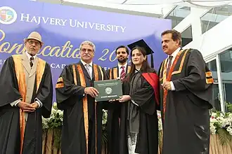 Graduates receiving academic degrees during an academic convocation ceremony.