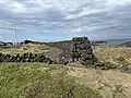 Sharply defined wall with a rock pathway on the landward side