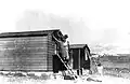 Weatherproofing being fixed to the exterior of first cabins at Harel. 27 October 1948.