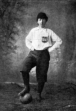 Black and white photo of Matthew wearing a white top with a football under her foot