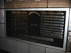A wall displaying a series of metallic rings which have inscriptions on them