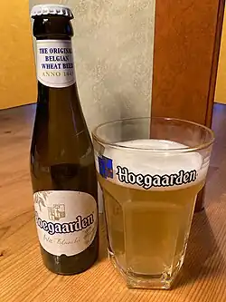 Bottle of Hoegaarden wheat beer with its iconic hexagonal glass