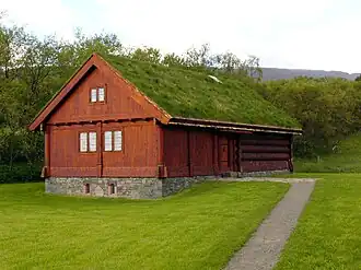 Wooden house with a stone foundation and a turf-covered roof