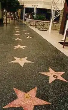 Charcoal sidewalk featuring two rows of alternating stars, one row full and the other with gaps. No pedestrians.