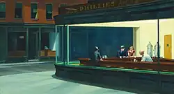 Several people sit at the counter of a brightly lit diner at night