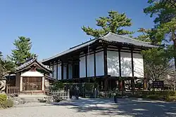 Wooden building with white walls on poles.