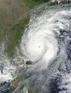 A satellite image of Cyclone Hudhud nearing the coast of India, showing curved banding and an eye