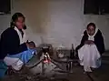 Indian schoolgirls in their uniforms making tea over an open fire