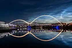 The Infinity Bridge, Stockton-on-Tees illuminated after sunset with rare noctilucent clouds across the sky.