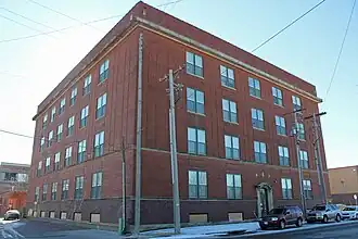 Intersection looking at four-story brick building
