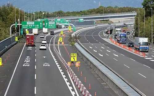 A group of green-coloured directional signs on a Japanese expressway