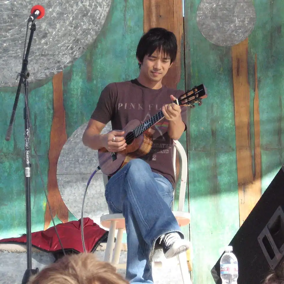 Shimabukuro seated and playing ukelele
