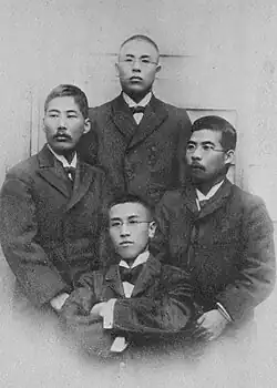 Photograph of four men wearing suits
