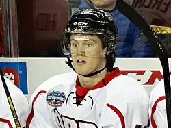Ice hockey player in a red and white jersey sitting with his mouth open