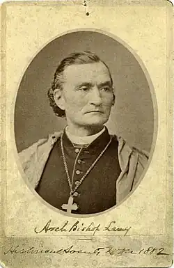 black-and-white photograph of a man wearing a pectoral cross